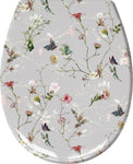 Grauer Toilettensitz mit zarten Blumenranken und bunten Schmetterlingen