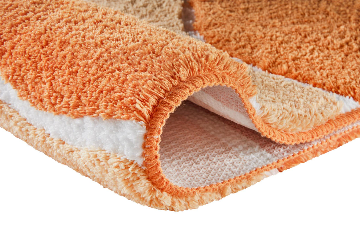 Orangener flauschiger Badteppich mit rutschfester Unterseite.