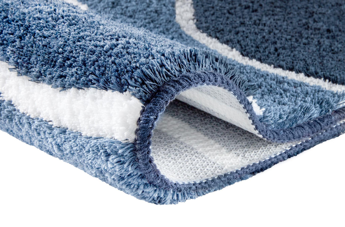 Blauer flauschiger Badteppich mit weißem Muster im Detail.