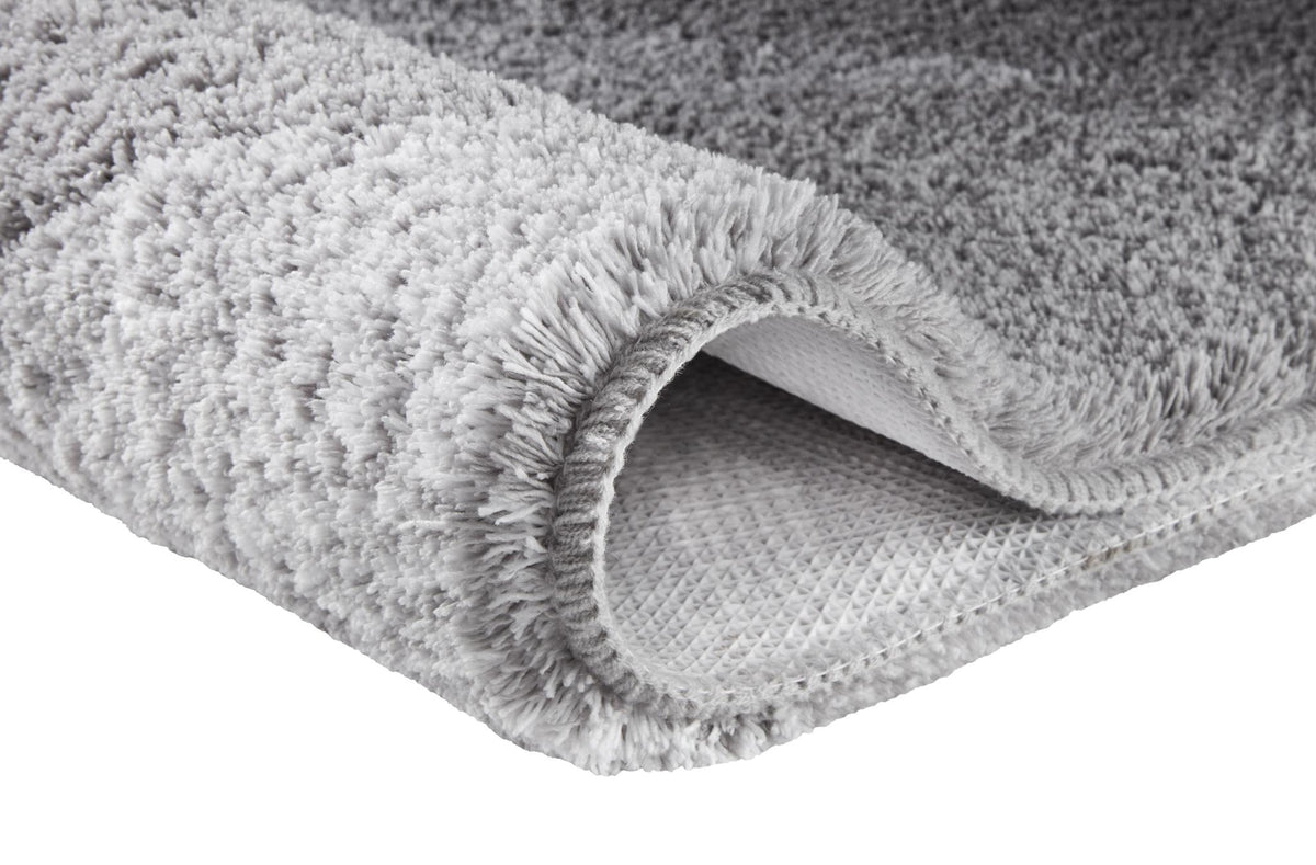 Grauer Hochflor-Teppich mit rutschhemmender Unterseite.