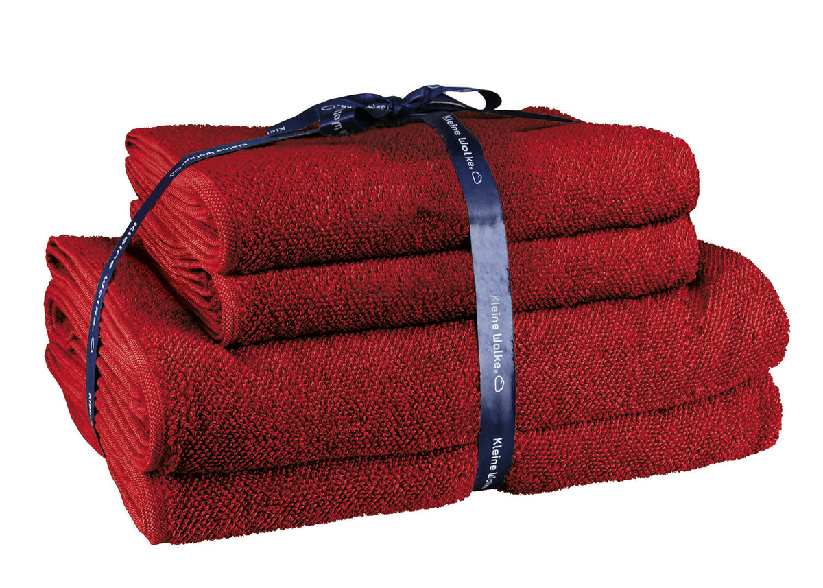 Gefaltetes rotes Handtuch-Set mit dunkelblauer Schleife gebunden