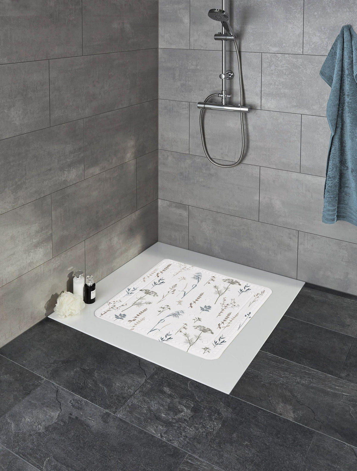 Begehbare Dusche mit grauen Fliesen und Duschmatte mit Blütenmotiv