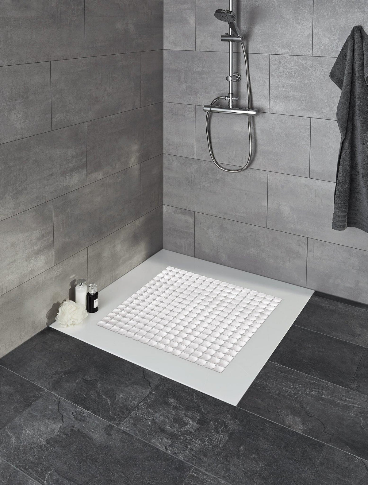 Begehbare Dusche mit grauen Fliesen und weißer rutschfester Matte