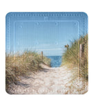 Sandweg durch Dünen mit Holzgeländer zum Meer unter blauem Himmel