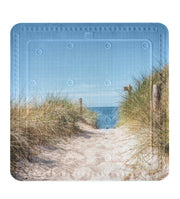 Sandweg durch Dünen mit Holzgeländer zum Meer unter blauem Himmel