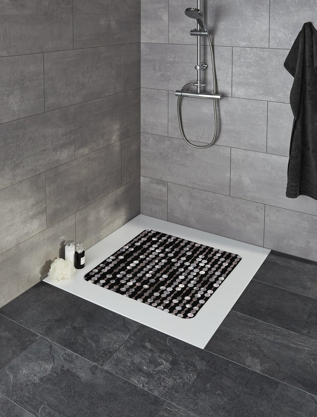 Moderne Dusche mit dunkel gemusterter Duschmatte auf weißer Duschwanne