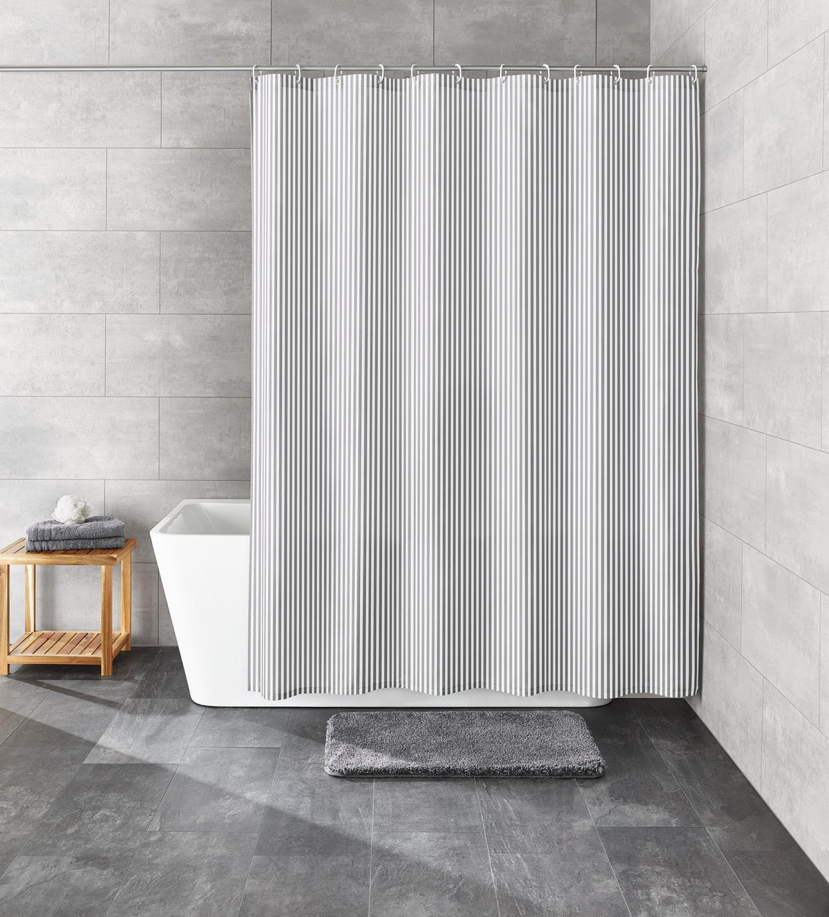 Grau-weiß gestreifter Duschvorhang vor Badewanne im modernen grauen Bad