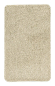 Rechteckige beige Badematte aus weichem Hochflor vor weißem Untergrund