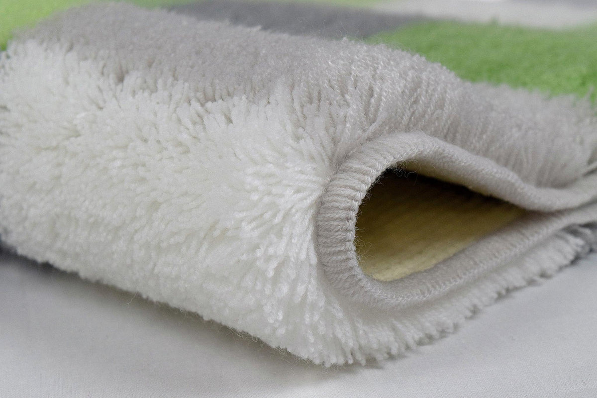 Gefaltetes, flauschiges Handtuch in Weiß, Grau und Hellgrün in Nahaufnahme