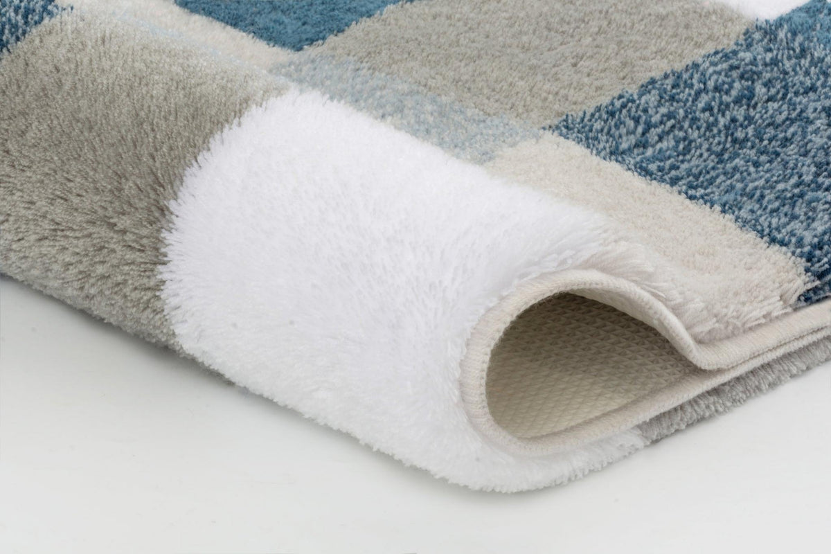 Weiche Badematte mit blau-grauen Karos und umgeschlagener Ecke vorn
