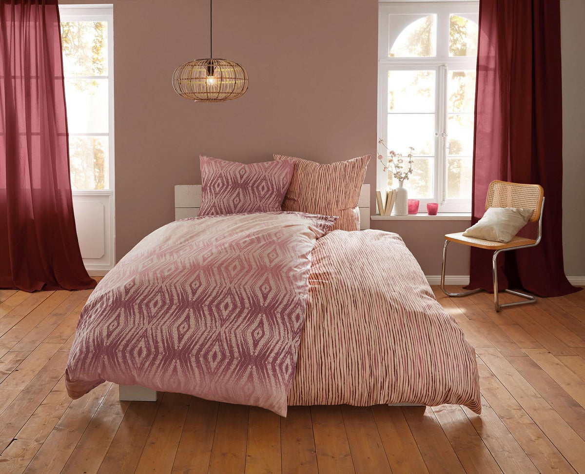 Doppelbett mit rosa gemusterter Bettwäsche in hellem Schlafzimmer