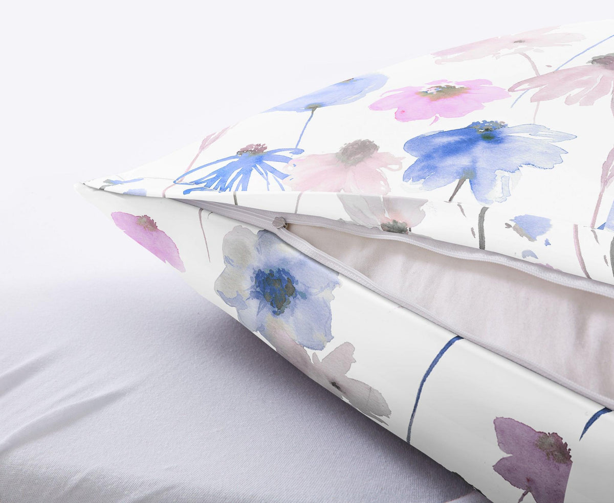 Kissen mit weißem Bezug und zarten Aquarellblumen in Pastellfarben