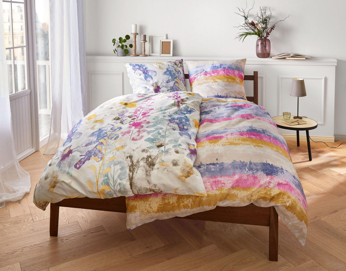 Doppelbett mit bunter Bettwäsche im Aquarellstil in hellem Schlafzimmer