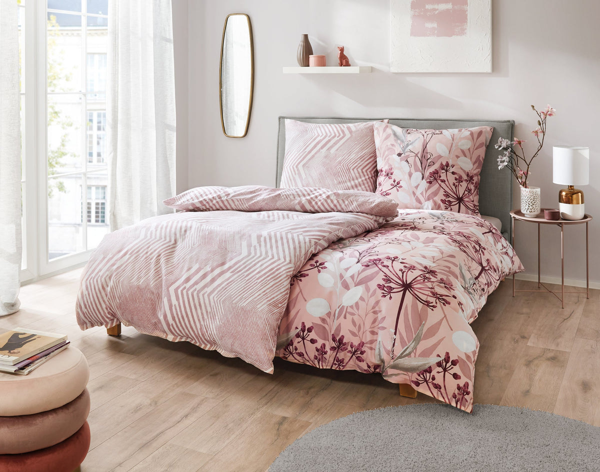 Doppelbett mit rosa gemusterter Bettwäsche in hellem Schlafzimmer
