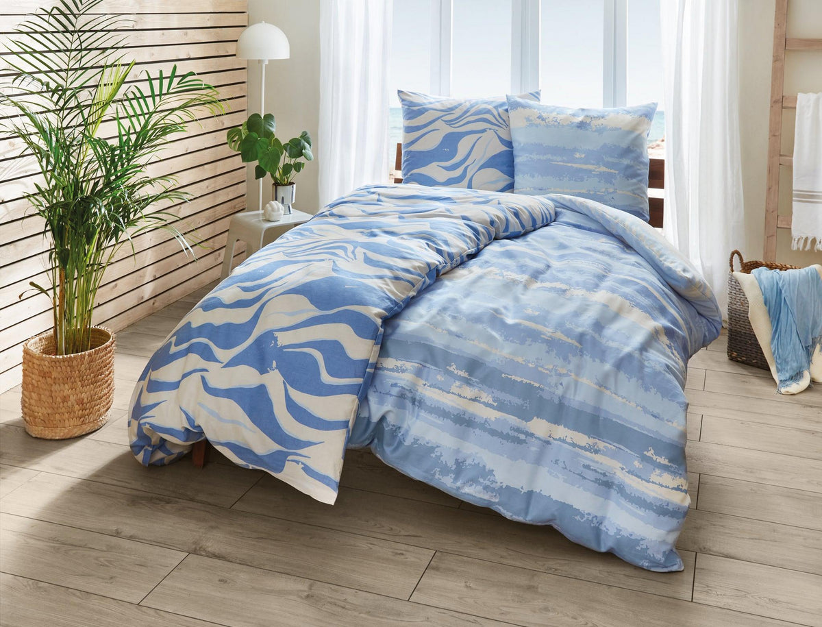 Bett mit blauer Bettwäsche im Wellenmuster in hellem, modernem Raum