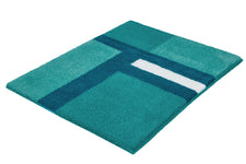 Ein türkisfarbener Badteppich mit blau-weißem Linienmuster liegt aus.