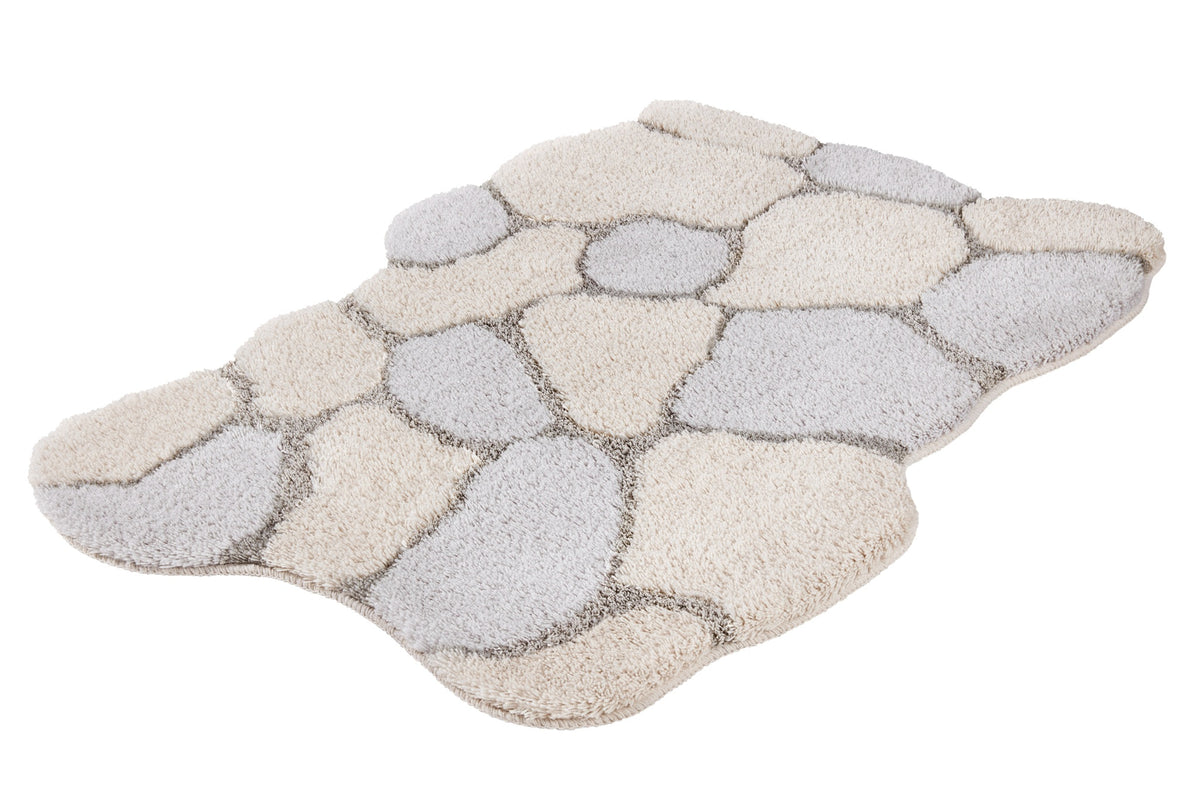 Der flauschige Teppich zeigt ein Kieselsteinmuster in Beige und Grau.
