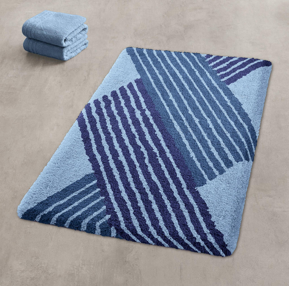 Hellblauer Badteppich mit dunkelblauem Streifenmuster und Handtüchern