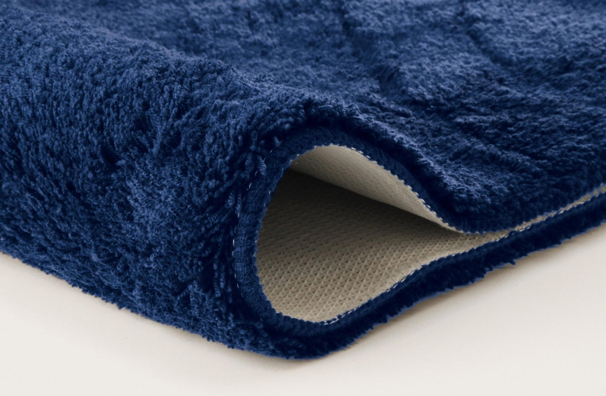 Nahaufnahme blaue Badematte mit hohem Flor und rutschfester Rückseite