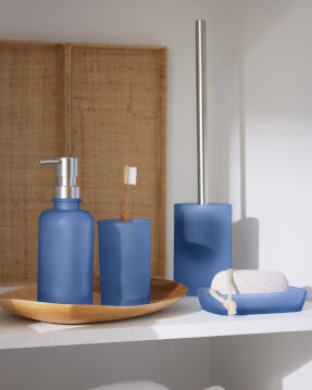 Blaues Badset mit Seifenspender, Zahnbürstenhalter und WC-Bürste.