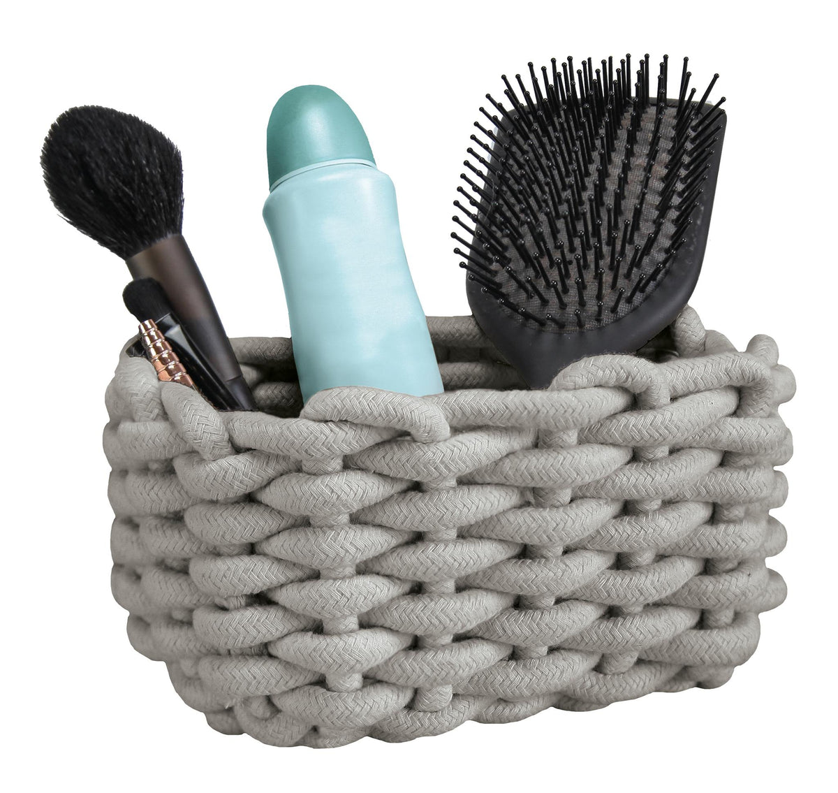 Grauer Flechtkorb mit Haarbürste, Deoroller und Make-up-Pinseln.