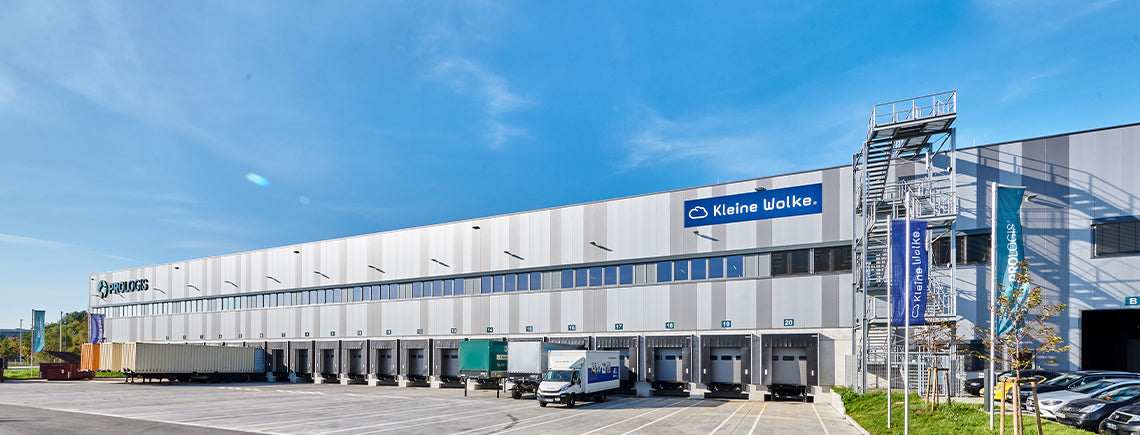 Modernes Logistikzentrum mit Laderampen und geparkten Lkw an der Halle
