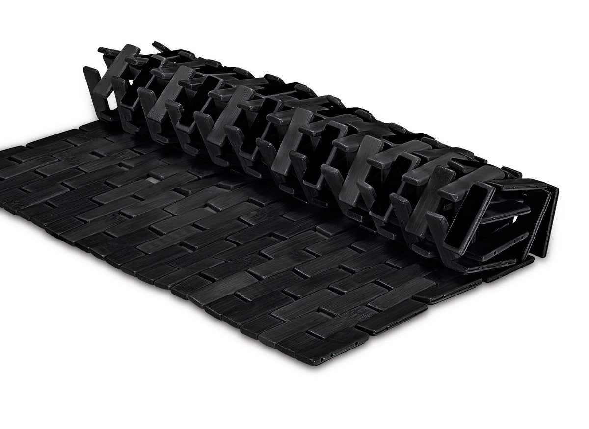 Schwarze, aufgerollte Badematte mit flexibler, geflochtener Struktur