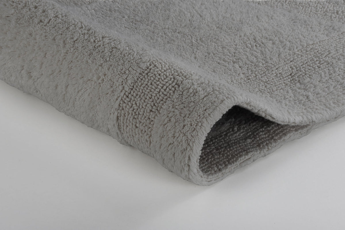 Nahaufnahme einer grauen, flauschigen Badematte mit deutlichem Texturdetail