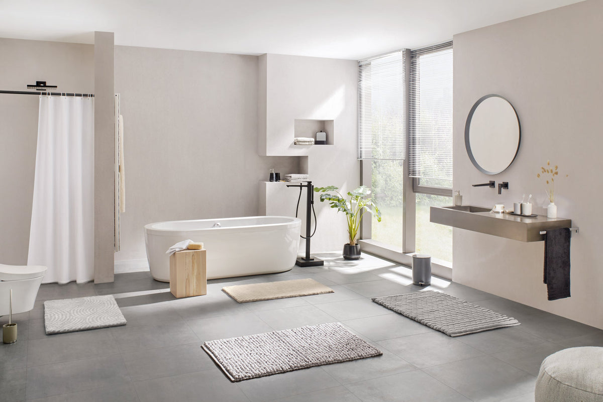 Modernes helles Badezimmer mit freistehender Wanne und Vorlegern
