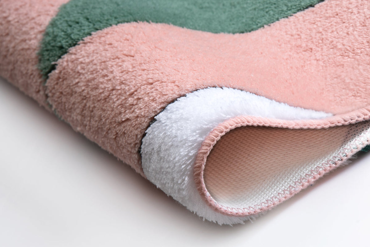 Weicher Badteppich in Rosa, Grün und Weiß in detailreicher Nahaufnahme
