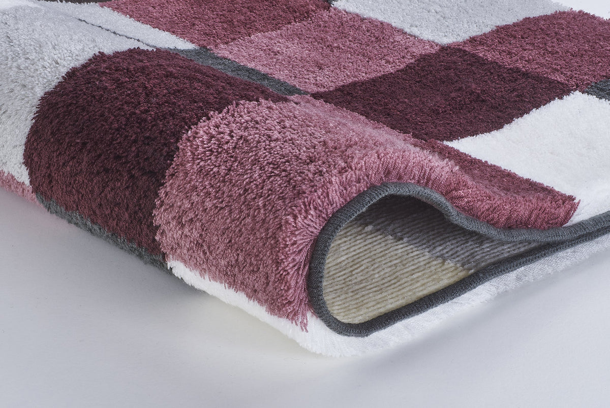 Nahaufnahme eines weichen karierten Badteppichs in Rosa und Bordeaux