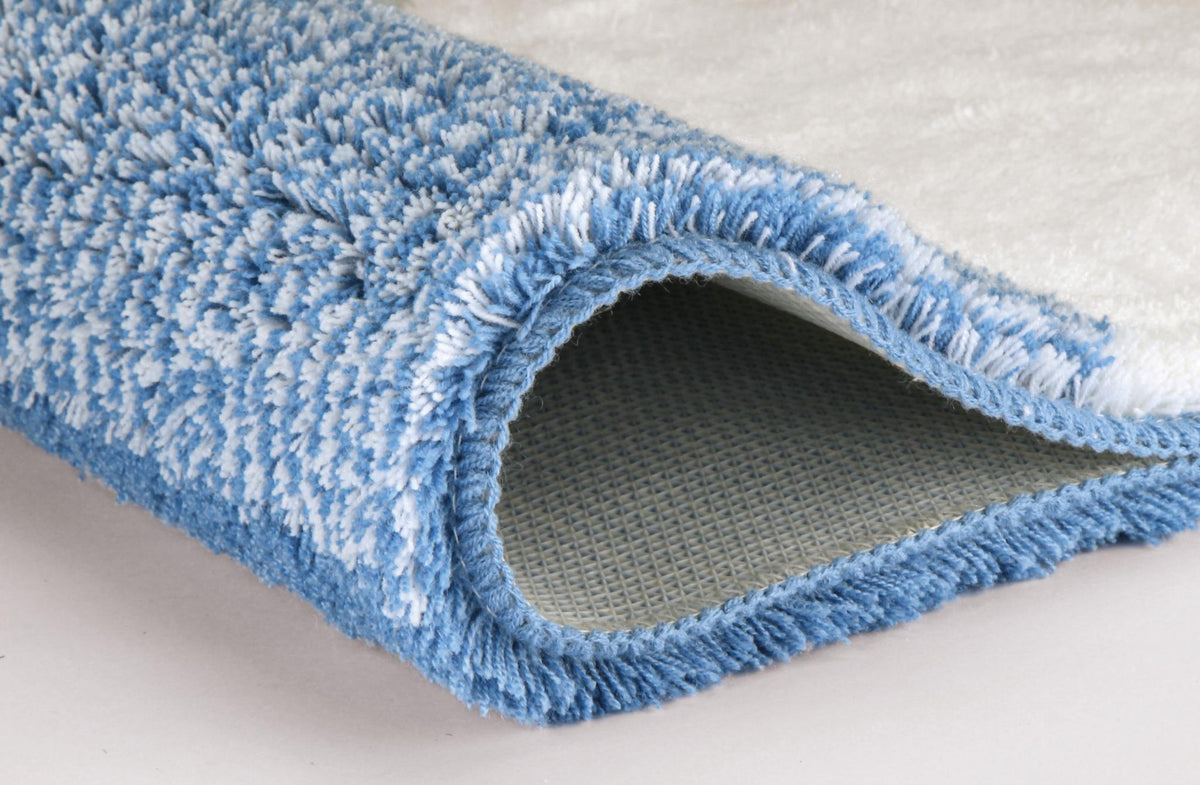 Blau-weißer flauschiger Badteppich mit umgeschlagener Ecke.