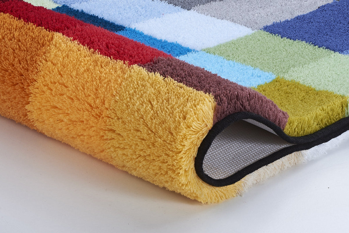 Nahaufnahme einer weichen, mehrfarbigen Badematte mit umgeklappter Ecke