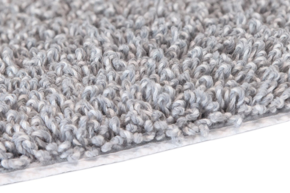 Detailansicht einer weichen, hellgrauen Badematte aus Hochflor