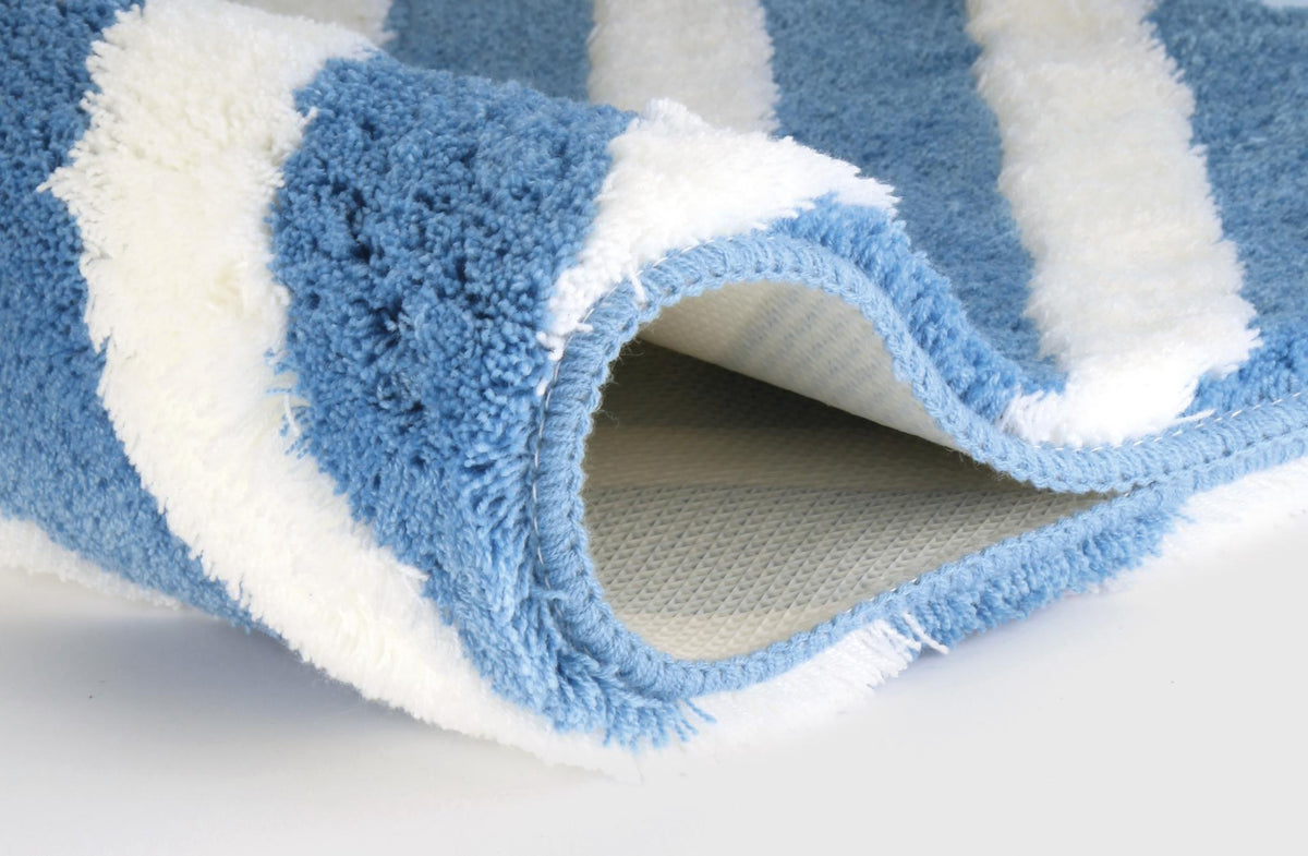 Blau-weißer flauschiger Badteppich mit umgeklappter Ecke.