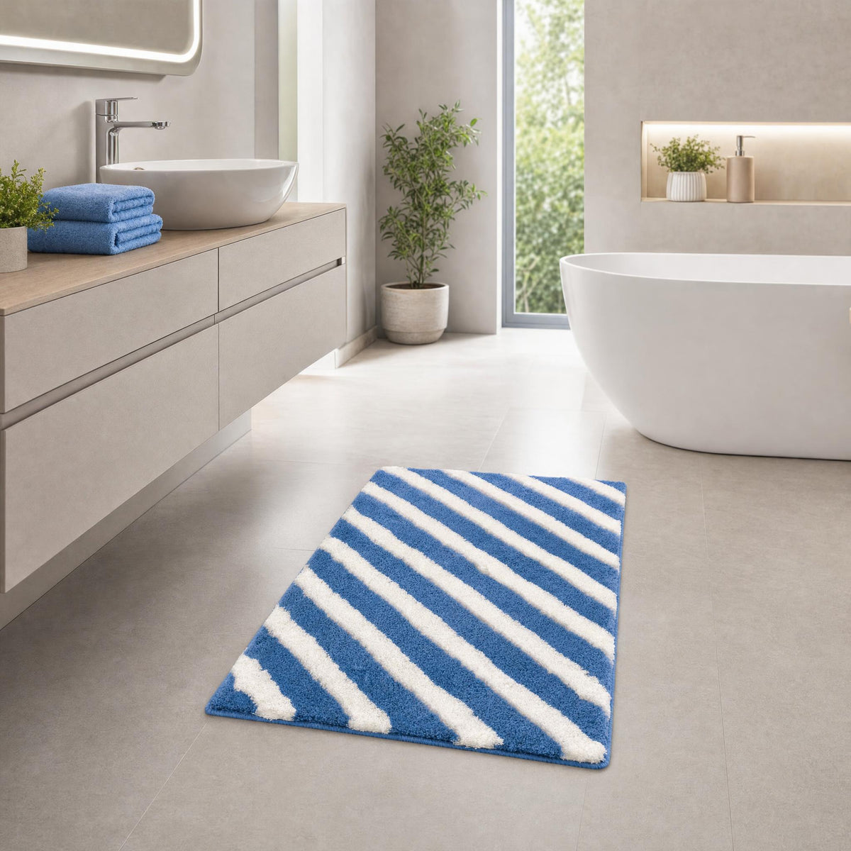 Blau-weißer Badteppich mit Streifen in modernem Badezimmer vor Badewanne.