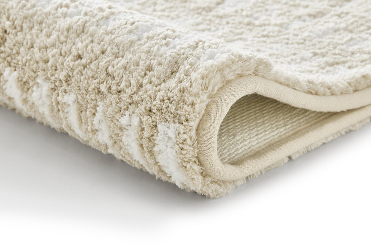 Beiger Badteppich mit Struktur, Nahaufnahme der weichen Oberfläche