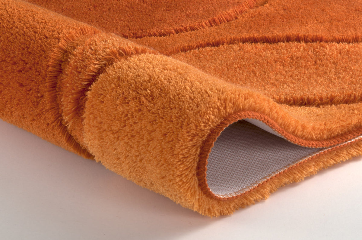 Orange Badematte in Nahaufnahme mit flauschigem Flor und Rückseite