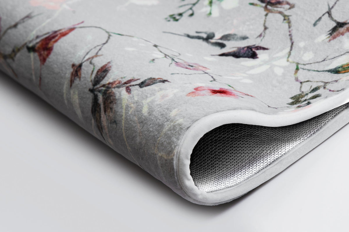 Nahaufnahme einer grauen Badematte mit zartem, buntem Blumenmuster