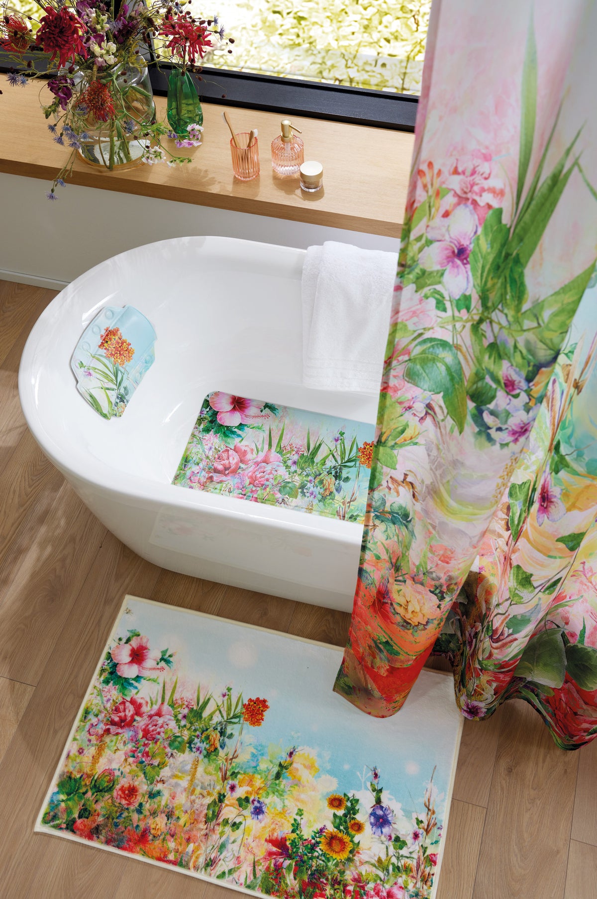 Bad mit floralem Duschvorhang, WC-Sitz-Bezug und buntem Badteppich.