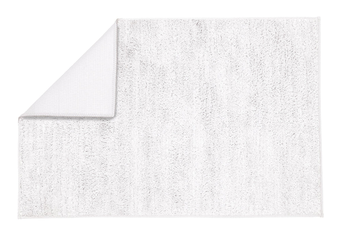 Weißer rechteckiger Badteppich mit umgeklappter Ecke oben links