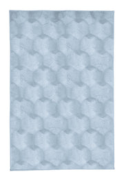 Hellblauer Badteppich in Wabenoptik auf Weiß. 