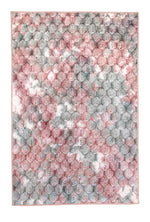 Flauschiger Teppich mit rosa-grauem Pomponmuster.