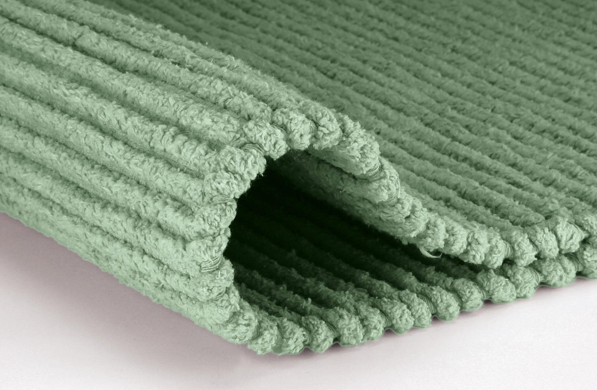 Gefalteter mintgrüner Badteppich mit weicher Rippenstruktur.