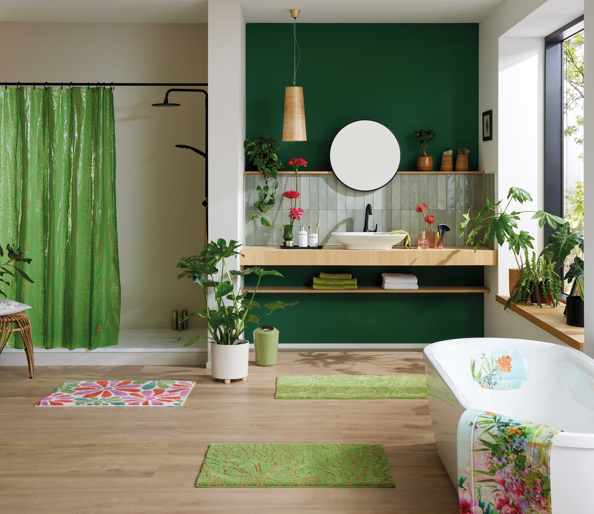 Modernes Bad mit grünen Badteppichen, Pflanzen und freistehender Wanne.