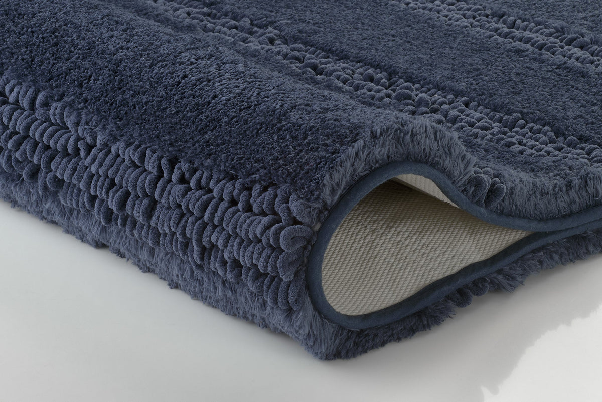 Dunkelblauer, flauschiger Badteppich aus Textil, seitlich eingerollt