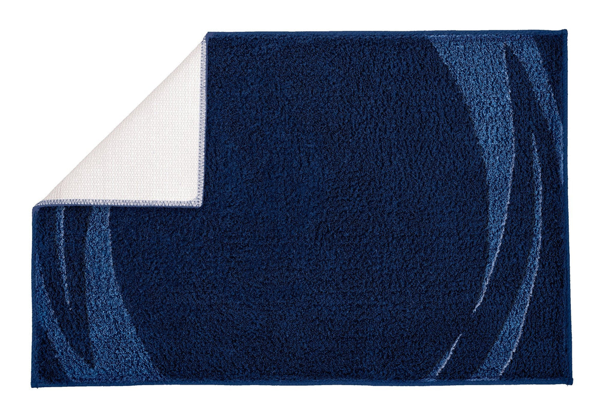 Dunkelblaue Badematte mit geschwungenem Muster und heller Rückseite
