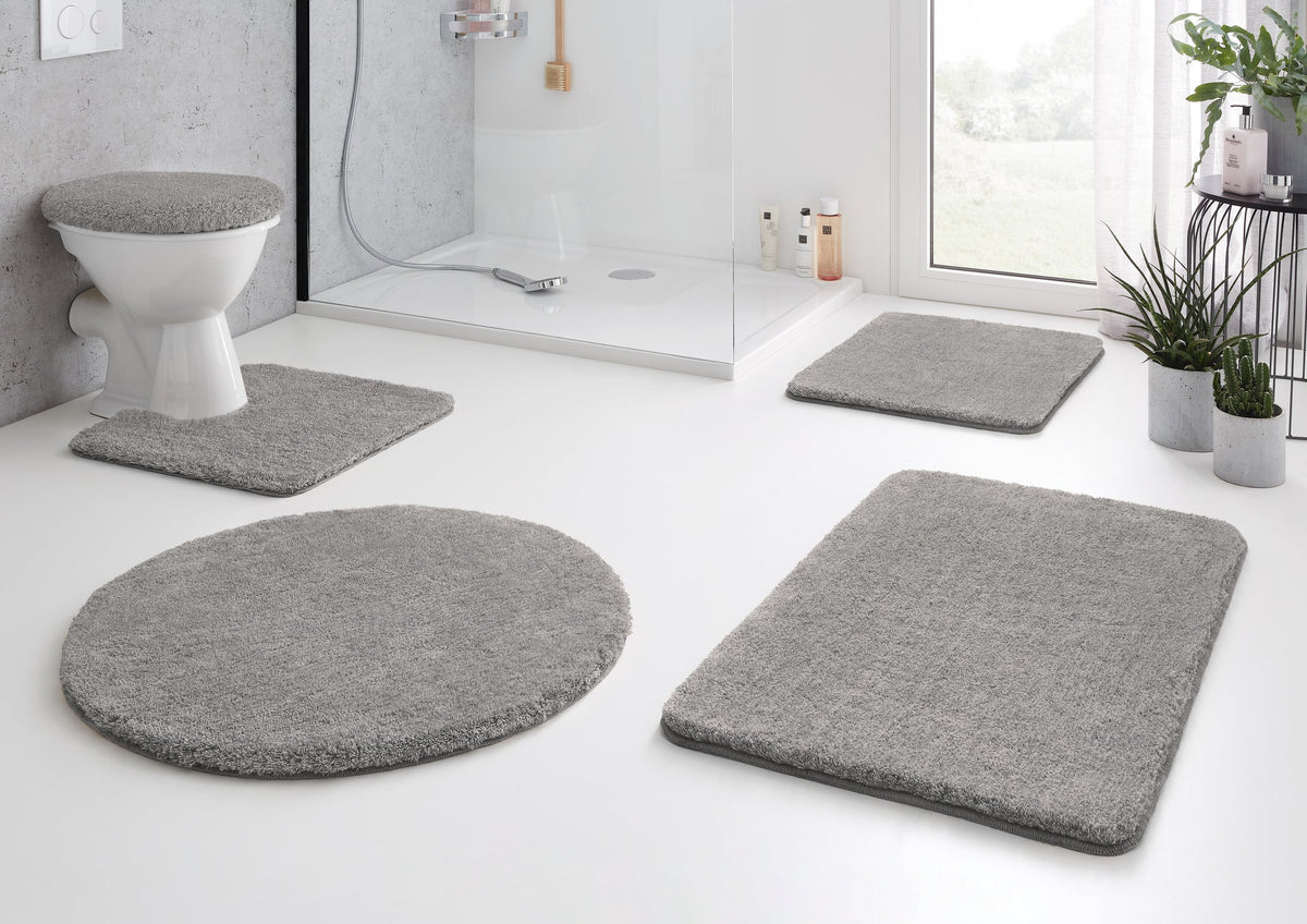 Graues Badteppich-Set mit WC-Deckelbezug in hellem, modernem Badezimmer