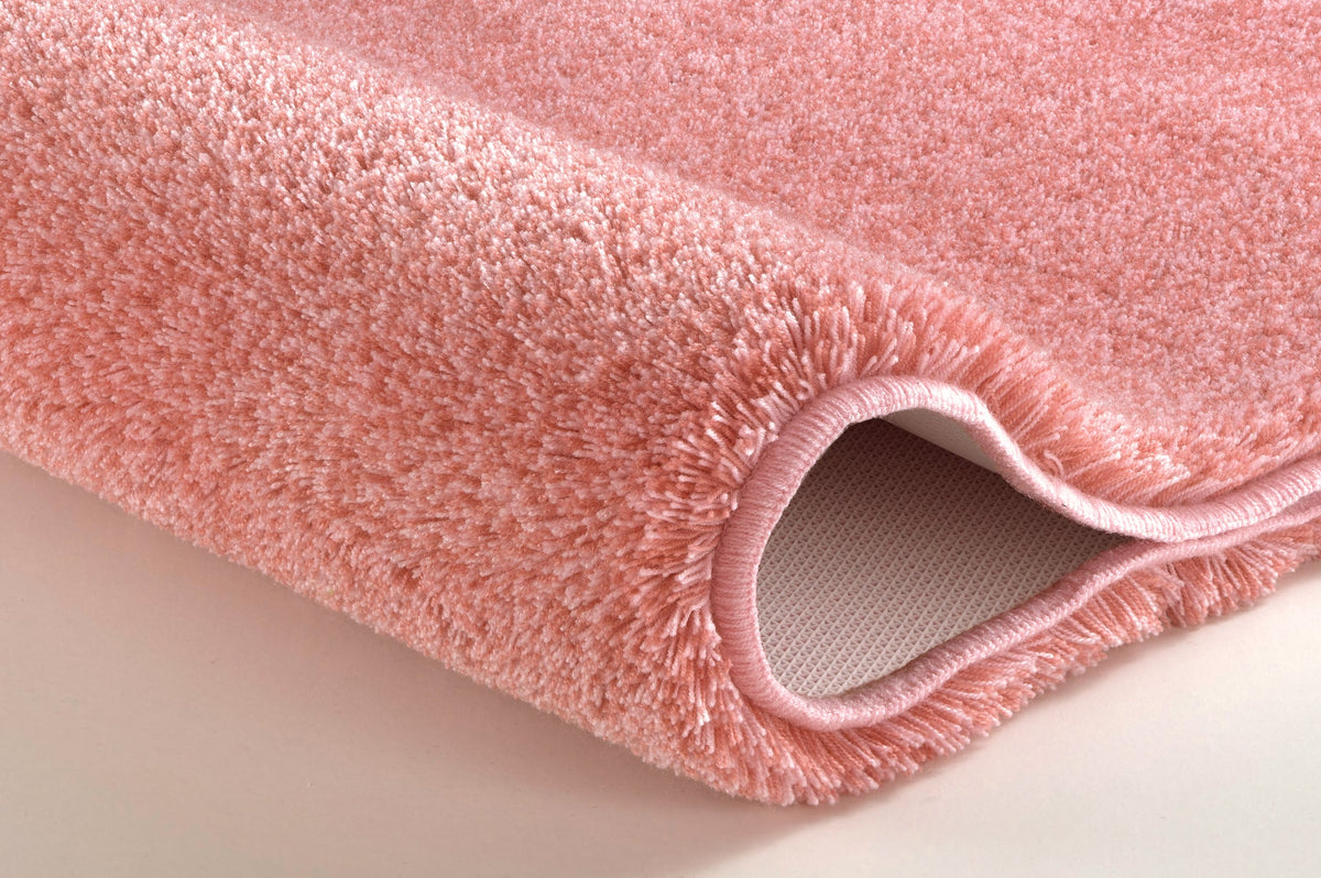Nahaufnahme eines rosa Badteppichs mit weichem, hochflorigem Flor