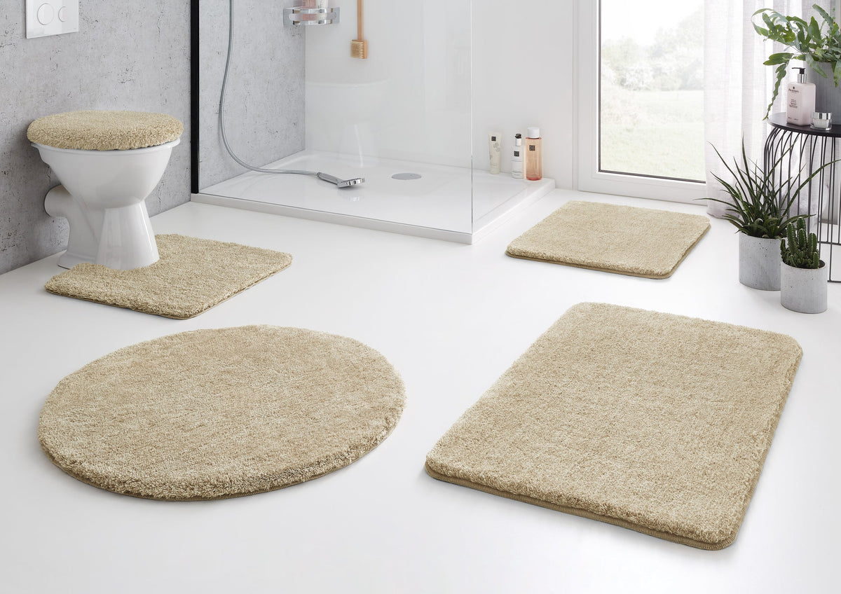Beiges Badematten-Set vor Dusche und WC in modernem Bad mit Pflanzen